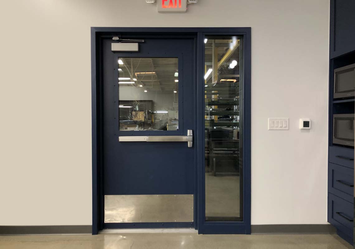 Acoustical door with vision lites between room and shop area.